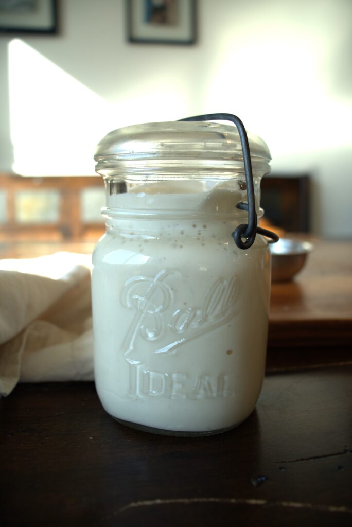 Active, bubbly, sourdough starter in a closed Ball jar.