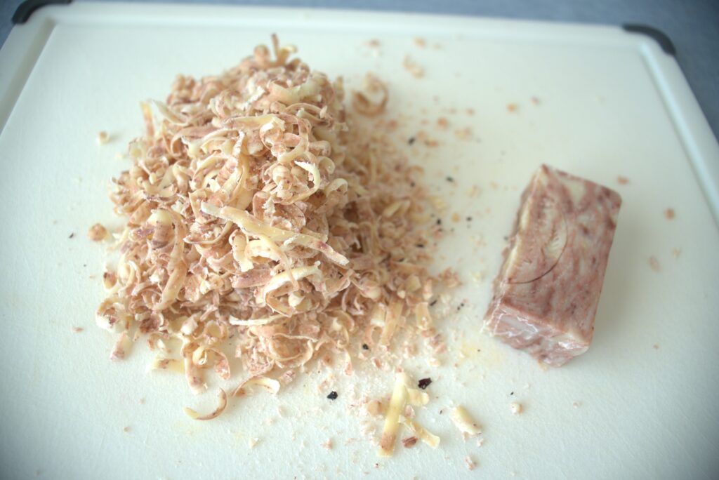 A shredded soap bar on a plastic cutting board.